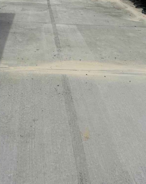 New concrete driveway with finished joints outside the garage at 1682 E 46th St in Brooklyn after replacement