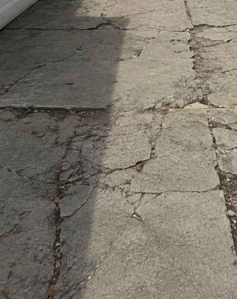 Cracked and broken concrete driveway outside the garage at 1682 E 46th St in Brooklyn before replacement
