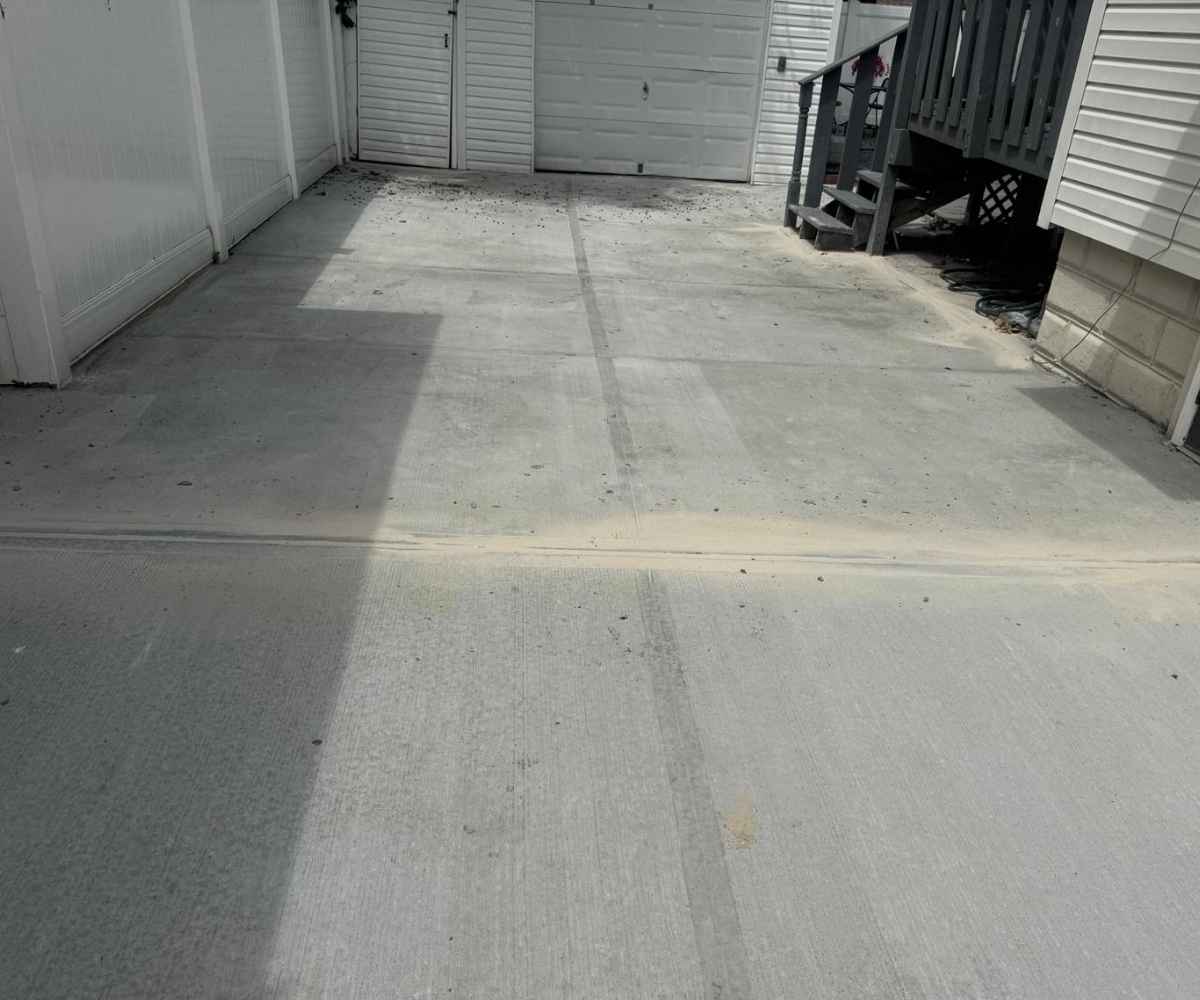 Newly installed concrete driveway with finished slabs and joints extending toward the rear garage in Brooklyn, NY.