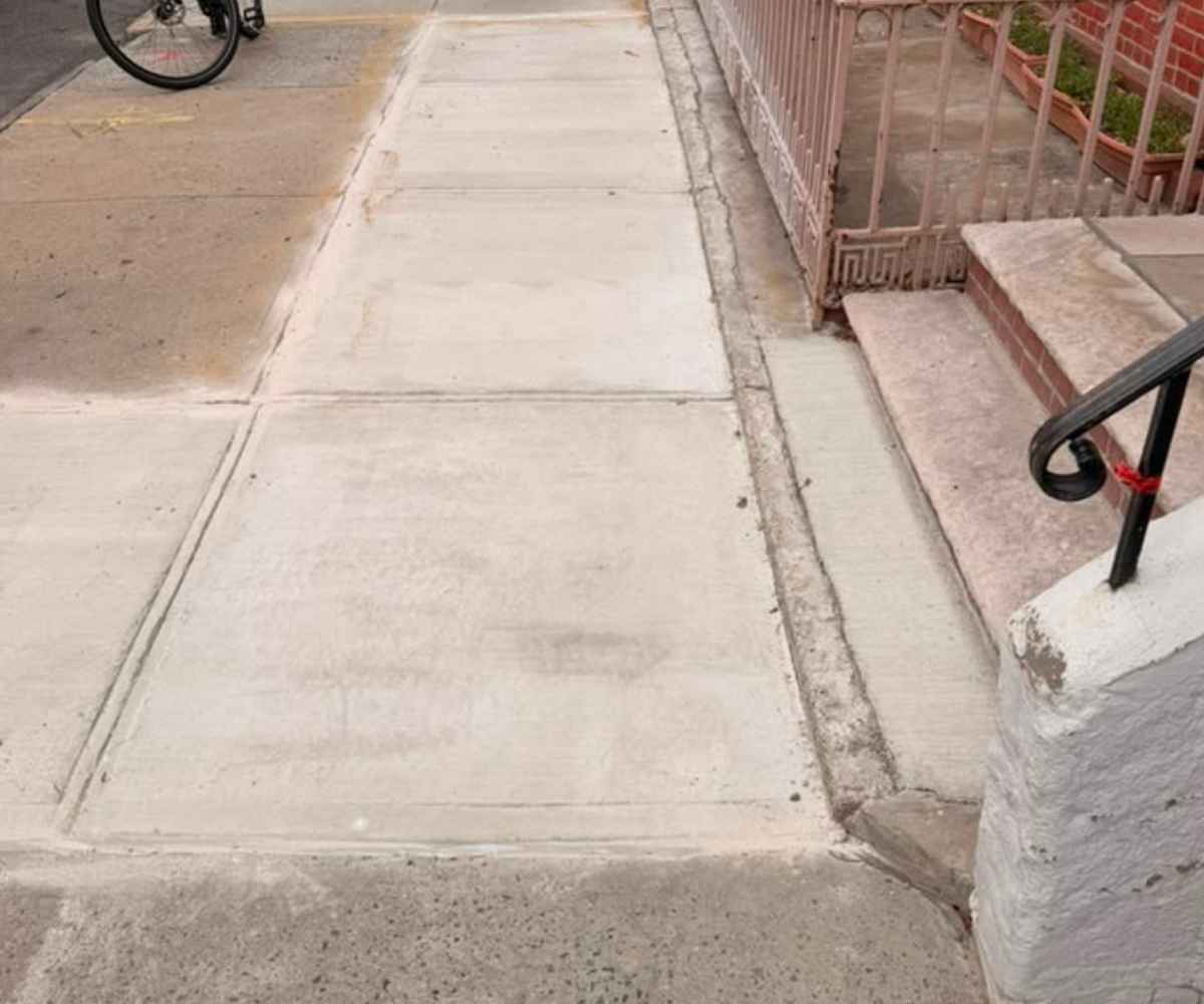Five newly replaced concrete sidewalk slabs at a residential property in Brooklyn